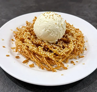 Crispy honey noodles with sesame and a scoop of vanilla ice cream