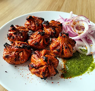 Tandoori momos with sliced red onion and green mint chutney