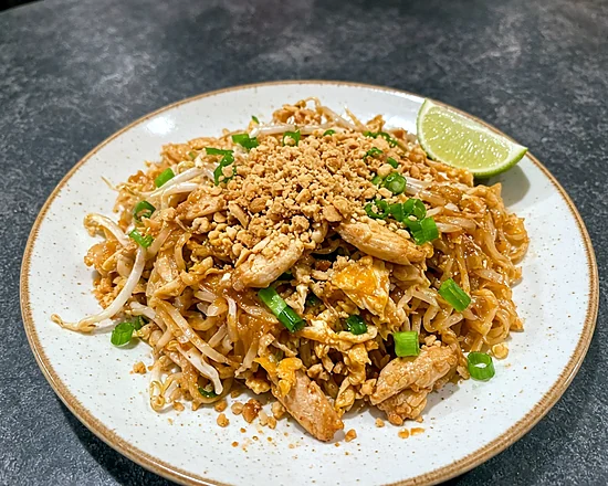 Chicken pad Thai with bean sprouts, crushed peanuts and a lime wedge